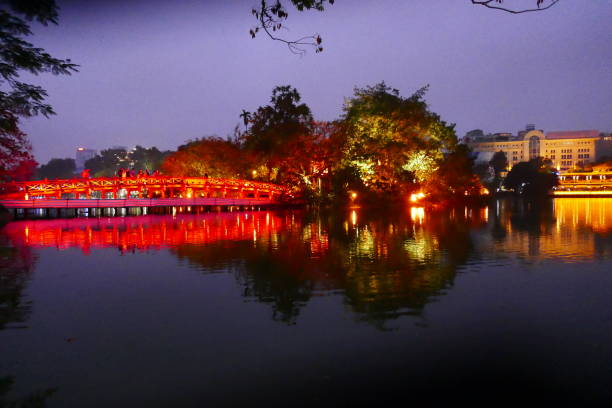 istock Orange lit bridge at night in Nha Trang reflected on the water 909030000