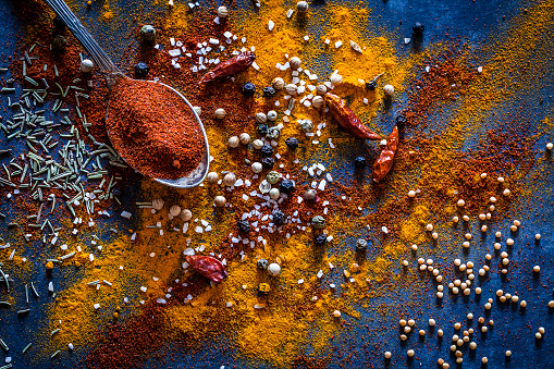 Top view of a bluish tint kitchen table with ground spices making a useful background. Low key DSRL studio photo taken with Canon EOS 5D Mk II and Canon EF 100mm f/2.8L Macro IS USM