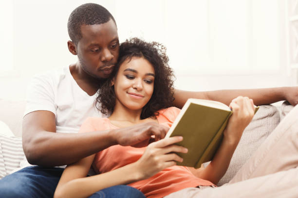 istock HAppy black couple reading together at home 909033450