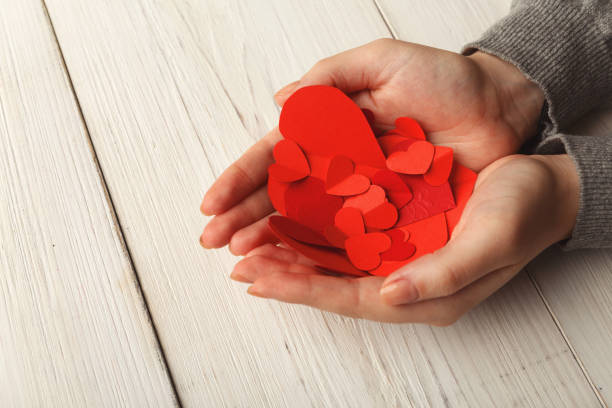 istock Valentine day background, hearts in female hands 909034098