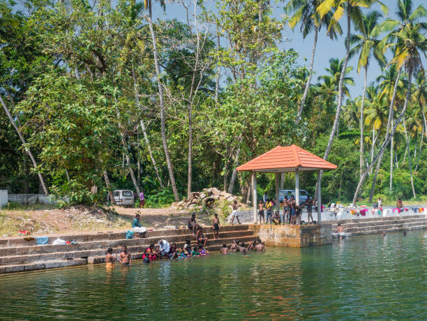 gli indiani si divertono in un vecchio pozzo, varkala, kerala, india - indian ethnicity traditional culture architecture karnataka foto e immagini stock