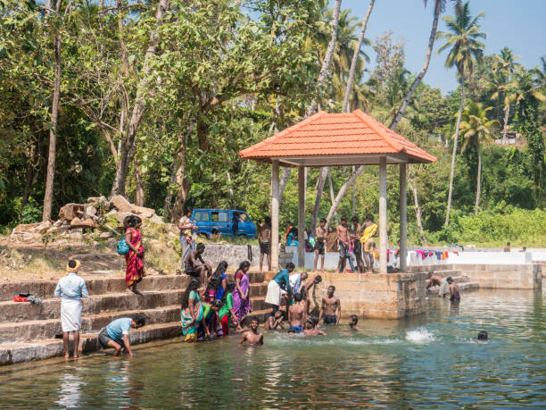 gli indiani si divertono in un vecchio pozzo, varkala, kerala, india - indian ethnicity traditional culture architecture karnataka foto e immagini stock