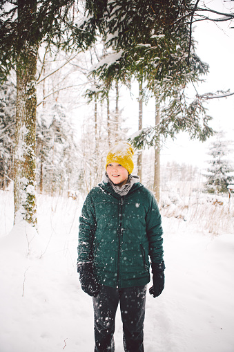 A teenage boy is ready to for a hike in winter forest. Lithuania, January 2018.