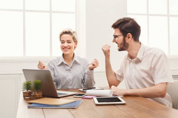 istock Young happy business partners in office with computer 909038170