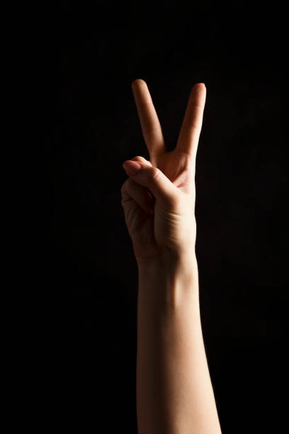 istock Female hand shows number two isolated at black 909041972