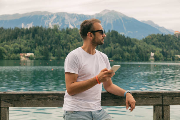 istock Tourist handsome man using smart phone outdoors. 909042362