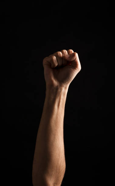 istock Hand gesture, man clenched fist, ready to punch isolated on black 909044930