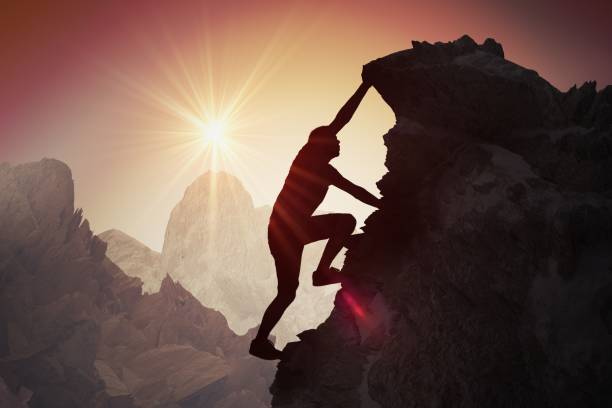 istock Silhouette of young man climbing on mountain. 909046450