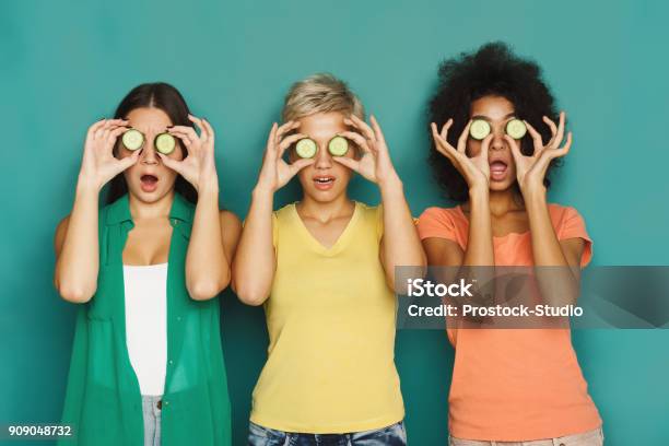 Photo libre de droit de Trois Belles Filles Qui Couvre Les Yeux Avec Des Morceaux De Concombre banque d'images et plus d'images libres de droit de Oeil