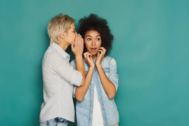 istock Young woman telling her friend some secrets 909048972