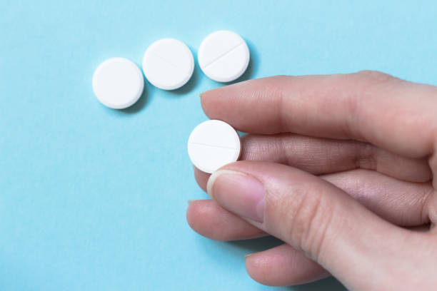 istock Female hand whire circle pill. Blue background. Medications. Concept medicine 909049018
