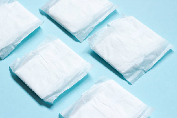 White feminine hygiene pad on blue backgroun. Macro, close up. stock photo