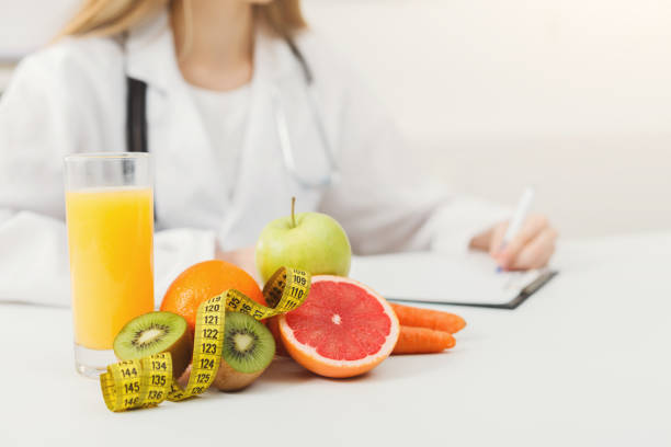 istock Nutritionist desk with fruit and measuring tape 909049248