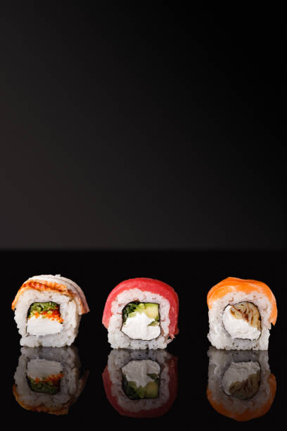 istock Japanese rolls on black mirroring background 909050272