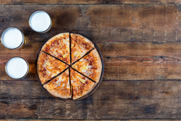 Beer and pizza on a wooden table. top view