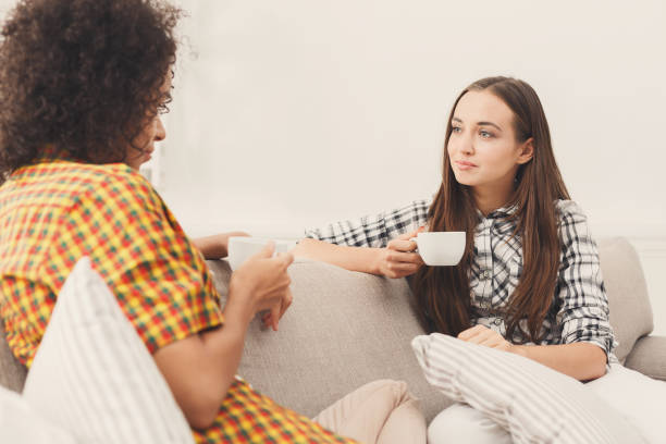 istock Two young female friends with coffee conversing 909067408