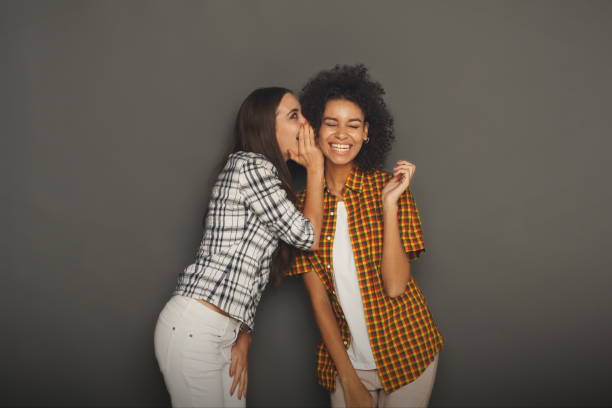 istock Young woman telling her friend some secrets 909070030