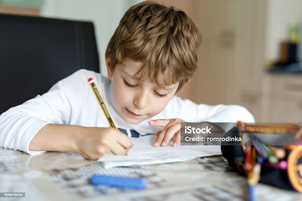 Niño niño cansado en casa haciendo tarea escribiendo cartas con plumas de colores - Foto de stock de Niño libre de derechos