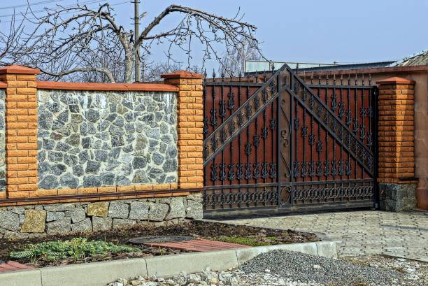 istock Iron forged gates and stone fence 909075644