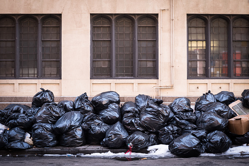 Ten of bags of trash abandoned on a sidewalk in New York