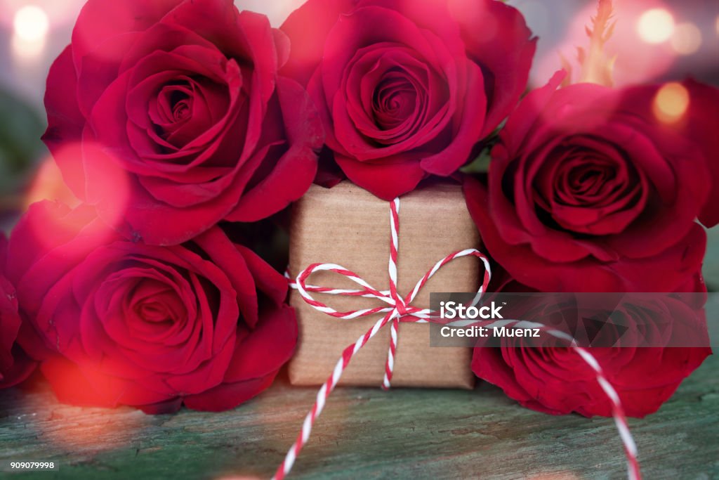 Red roses with a gift for valentines day Red roses with gift in shabby chic style and bokeh for valentines day 50th Anniversary Stock Photo