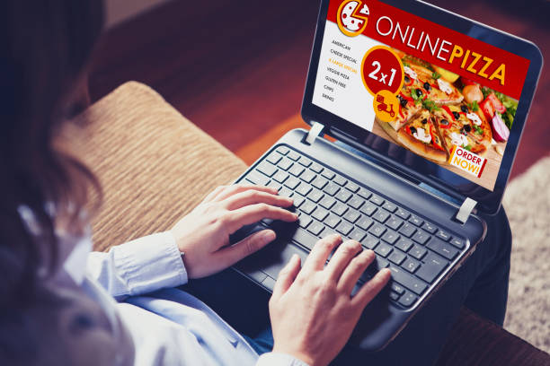 istock Woman using a laptop computer to order a pizza by internet. 909080096
