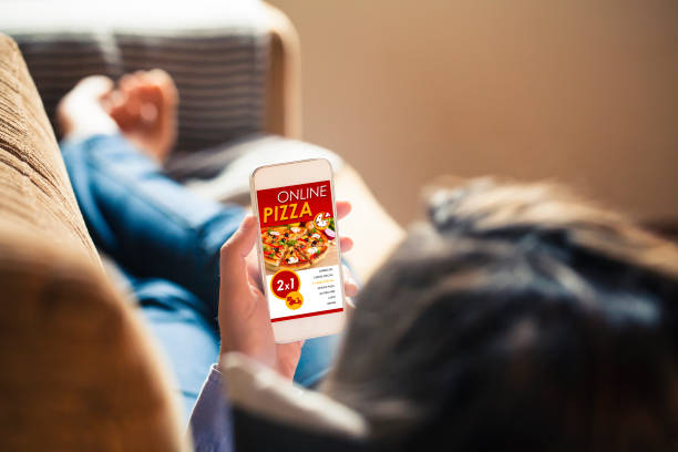 kobieta trzymająca telefon komórkowy ze stroną internetową pizzerii na ekranie. - pizza one person service human hand zdjęcia i obrazy z banku zdjęć