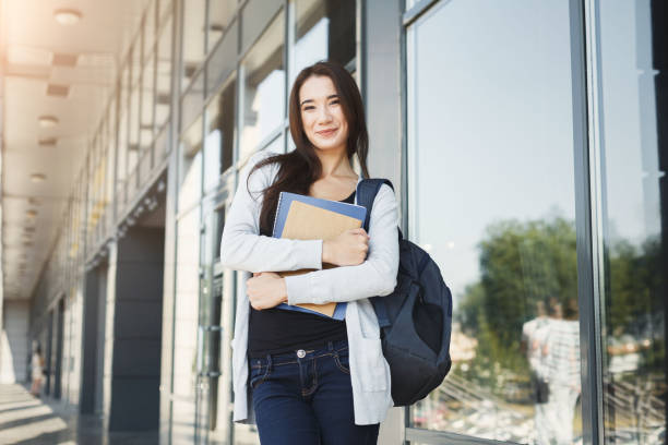 istock Student girl with books on university background 909084168