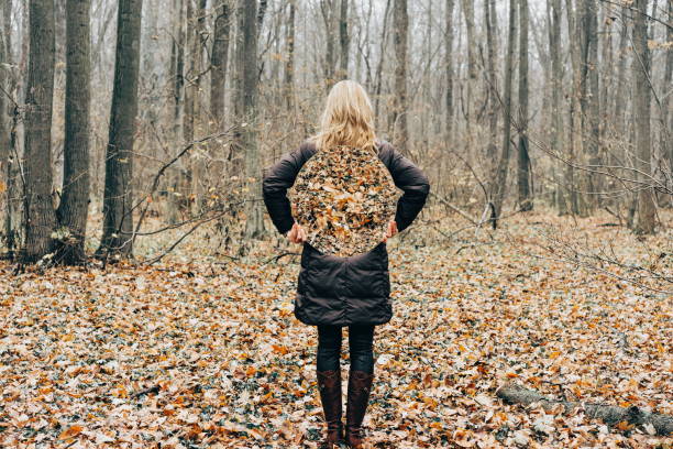 istock Rear View Of Woman Holding Mirror While Standing In Forest 909084286