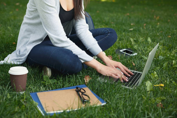 istock Young pensive woman using laptop in park 909084454