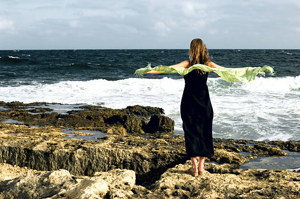 istock Woman staying at the seashore , windy day 90908505