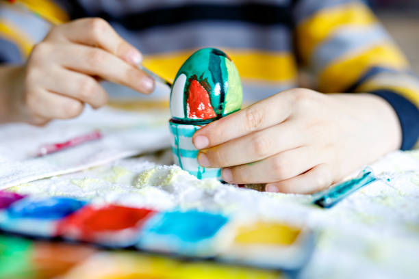 istock Close-up of little kid hands coloring eggs for Easter holiday 909089344