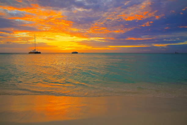 idilliaca spiaggia tropicale al tramonto drammatico con barche e yacht, paradiso estivo delle bahamas, mare caraibico - nassau foto e immagini stock