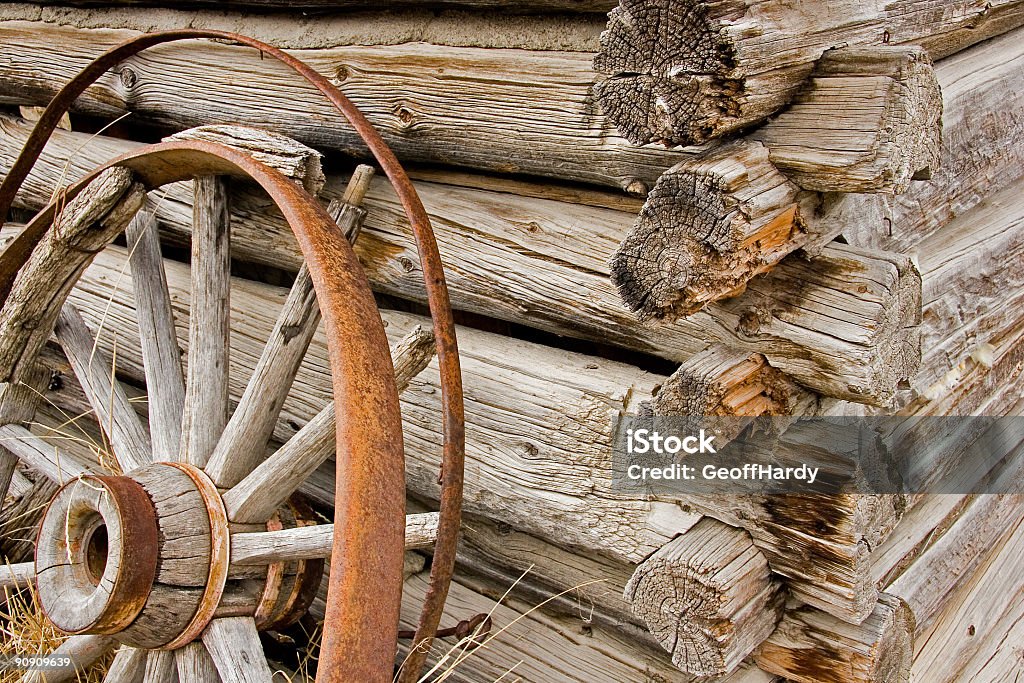 Rusty rueda de carro fuertemente contra una pared de madera - Foto de stock de Agrietado libre de derechos