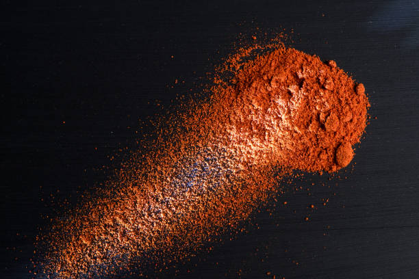 istock paprika powder on black background, top view 909096644