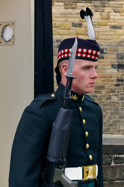 Soldier of the Royal Regiment of Scotland in full dress uniform carrying his rifle with fixed bayonet guarding the entrance of Edinburgh Castle stock photo
