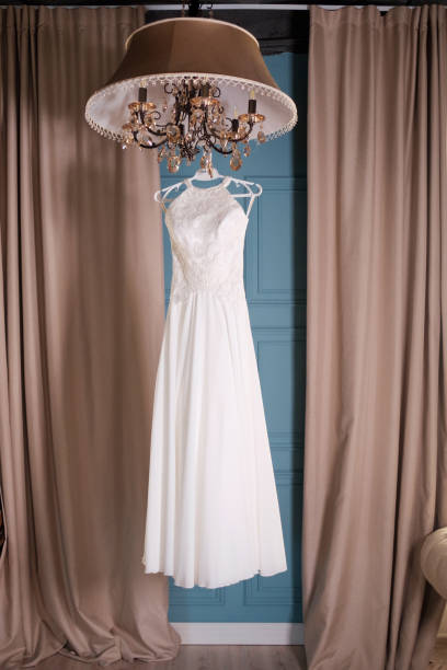 istock wedding dress handing on studio 909097486