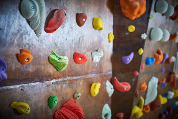 istock Wooden wall with climbing holds in gym 909097514