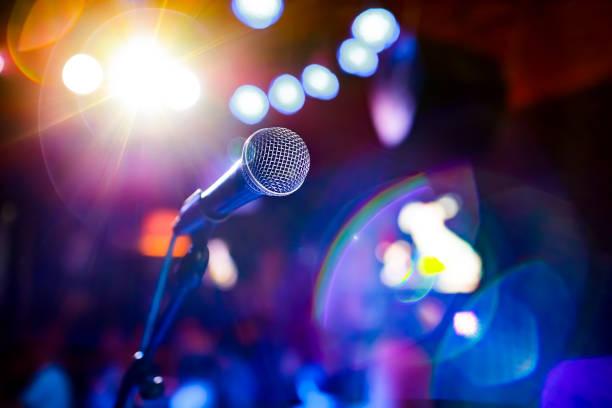 istock Microphone on stage against a background of auditorium. 909097778