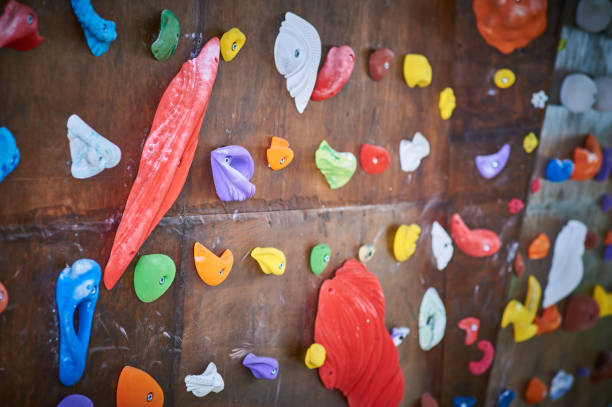 istock Wooden wall with climbing holds in gym 909097782
