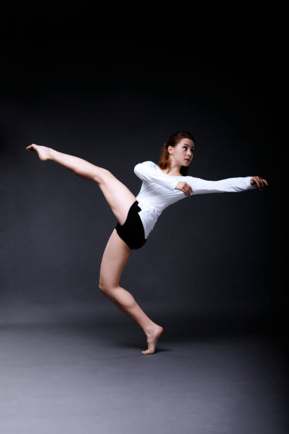 istock Young woman contemporary dancer posing in dark studio 909098040