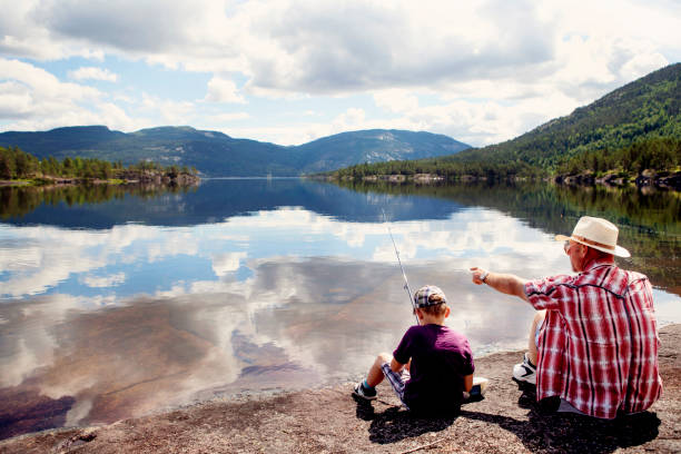 istock Grandfather teaches his grandson how to fish. 909098108
