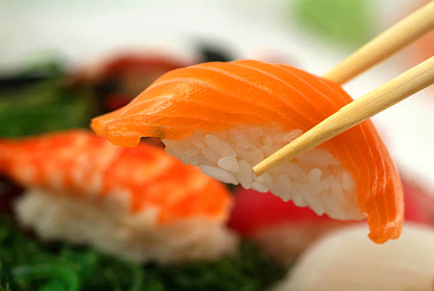 istock Freshly made sushi being held by a pair of chopsticks 90910070