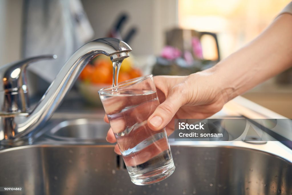 Pouring Fresh Tap Water Into a Glass Filling up a glass of water Water Stock Photo
