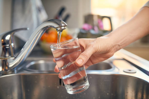 pouring fresh tap water into a glass - faucet imagens e fotografias de stock