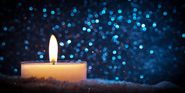 istock Chistmas candle glowing on glitter background. 909106294