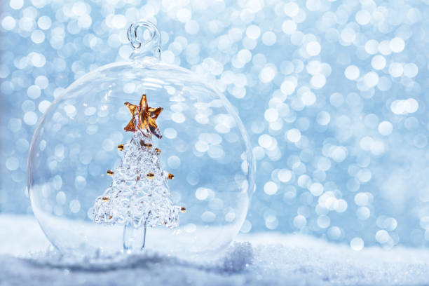 istock Christmas glass ball with crystal tree inside in snow 909106296
