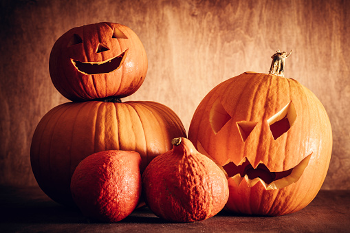 Halloween pumpkins, carved jack-o-lantern. Wooden background, vintage