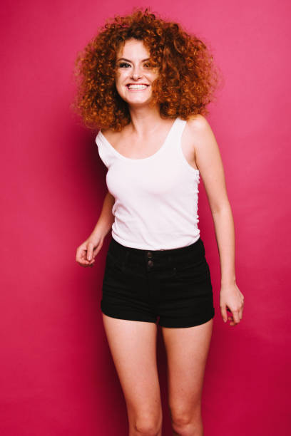 studio portrait of attractive young redhead girl over pink wall - fashionable the human body short hair human head imagens e fotografias de stock