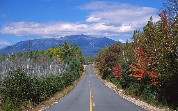 Mountain Road Autumn colors along a scenic road in the White Mountains of maine. Photo taken during the peak fall foliage season. Maine fall foliage ranks with the best in New England bringing out some of  the most beautiful foliage in the United States mt katahdin stock pictures, royalty-free photos & images